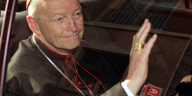 FILE - In this April 23, 2002 file photo Cardinal Theodore McCarrick of the Archdiocese of Washington, waves as he arrives at the Vatican in a limousine. On Saturday, Feb. 16, 2019 the Vatican announced Pope Francis defrocked former U.S. Cardinal Theodore McCarrick after Vatican officials found him guilty of soliciting for sex while hearing Confession. (AP Photo/Andrew Medichini, file)