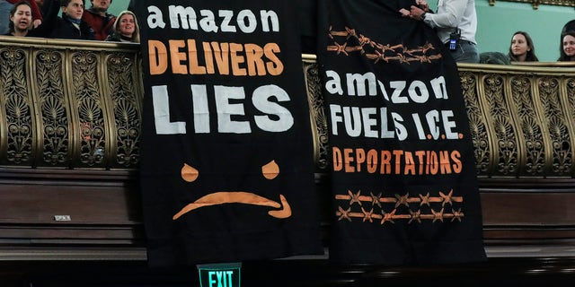 Protestors unfurled anti-Amazon banners from the balcony of a hearing room during a New York City Council Finance Committee hearing at New York City Hall, January 30, 2019.  (Photo by Drew Angerer/Getty Images)