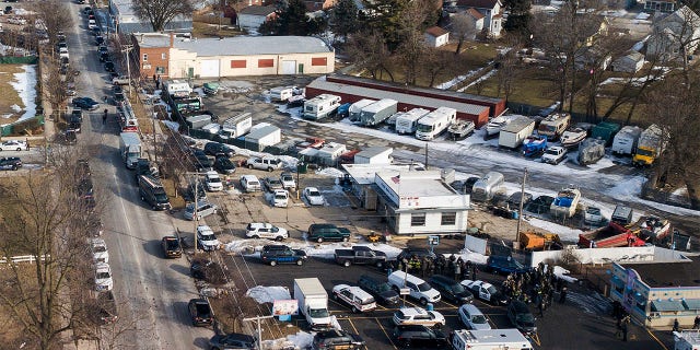 Law enforcement personnel gather near the scene of a shooting at an industrial park in Aurora, Ill., on Friday, Feb. 15, 2019.