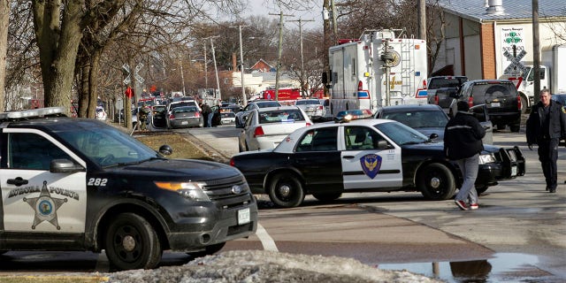 Law enforcement personnel gather near the scene of a shooting at an industrial park in Aurora, Ill., on Friday, Feb. 15, 2019.