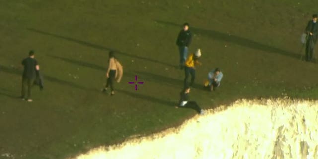 Tourists were caught on camera dangling their feet over the cliff's edge.