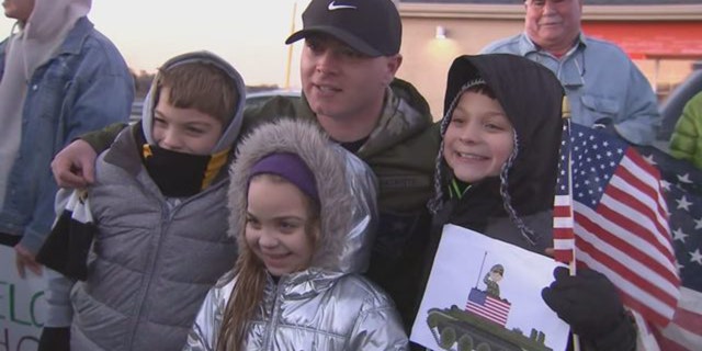 Beau Schlichting posed with young well-wishers at his suprising homecoming party Saturday in Winthrop, Mass. Schlichting returned home after a nine-month deployment in Afghanistan with the U.S. Army.