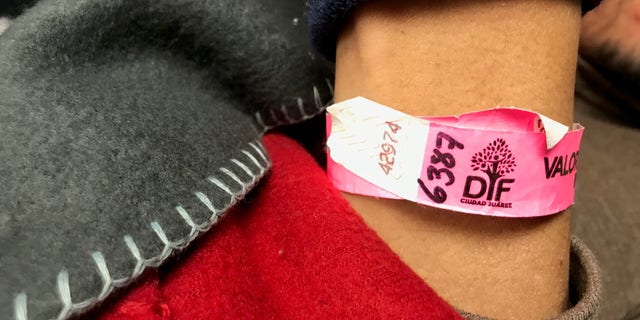 Migrants are issued pink wrist bands marked with a number to wait their turn to apply for asylum at the El Paso ports of entry.