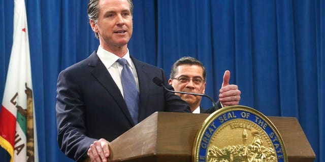 California Gov. Gavin Newsom, left, flanked by Attorney General Xavier Becerra, right, answers a question concerning a lawsuit the state will likely file against President Donald Trump over his emergency declaration to fund a wall on the U.S.-Mexico border Friday, Feb. 15, 2019, in Sacramento, Calif. Newsom and Becerra both say there is no emergency at the border and Trump doesn't have the authority to make the declaration. (AP Photo/Rich Pedroncelli)