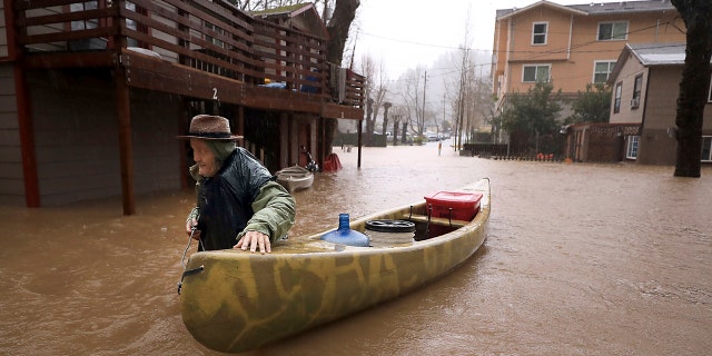 A Sycamore Court resident, Jesse Hagan, is evacuating to higher ground in the Lower Guerneville, California, apartment complex on Tuesday, February 26, 2019.