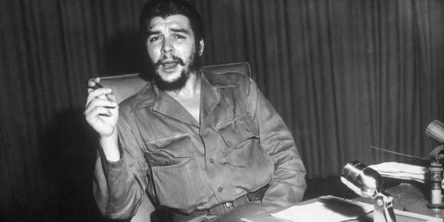 1960- Portrait of Ernesto "Che" Guevara, Cuban revolutionary leader, sitting at a desk. 