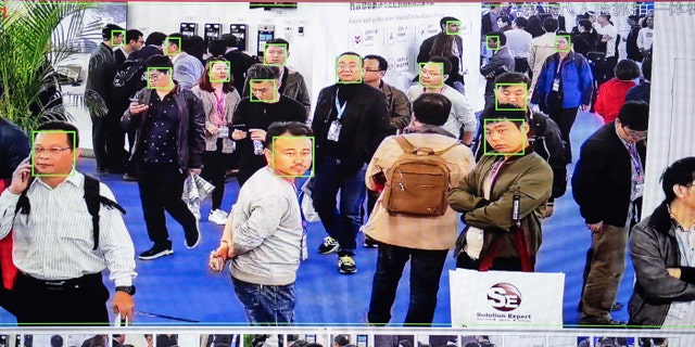 A screen shows visitors being filmed by AI (Artificial Intelligence) security cameras with facial recognition technology at the 14th China International Exhibition on Public Safety and Security in Beijing.