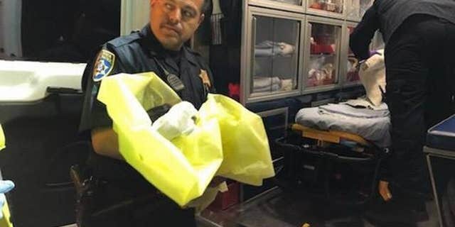 The California Highway Patrol's Alfred Medina holds the infant girl who was found in the town of Madera Ranchos.