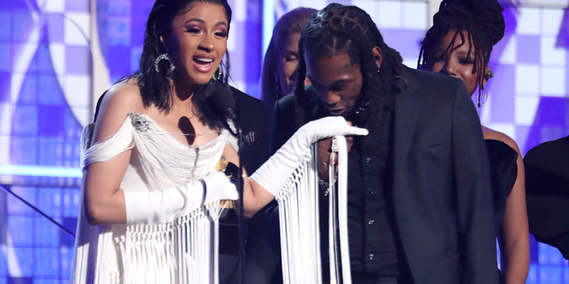 Cardi B, left, accepts the award for best rap album for "Invasion of Privacy" as Offset kisses her hand at the 61st annual Grammy Awards.
