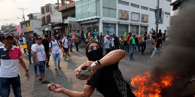 A demonstrator throws rocks during clashes with the Bolivarian National Guard in Urena, Venezuela, near the border with Colombia, Saturday, Feb. 23, 2019