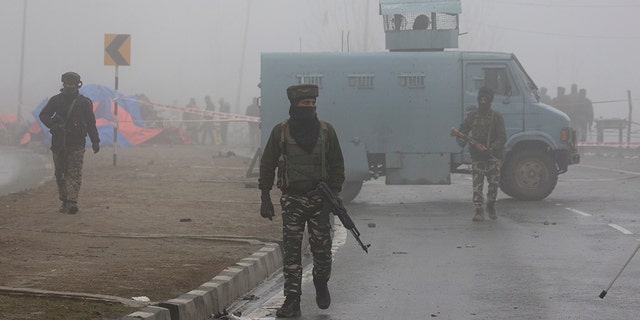Indian paramilitary soldiers patrol near the site of Thursday's suicide bombing attack in Pampore, Indian-controlled Kashmir, Friday.
