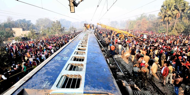 Rescue workers look for survivors as locals stand around the derailed coaches of a train, 30 kilometers (20 miles) north of Patna, the Bihar state capital of India, Sunday, Feb. 3, 2019. (AP Photo)
