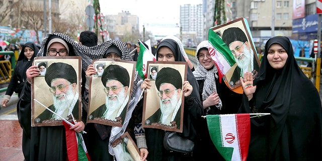 Iranian women hold up portraits of Iranian Supreme Leader Ayatollah Ali Khamenei, during a rally marking the 40th anniversary of the 1979 Islamic Revolution, in Tehran, Iran, Monday, Feb. 11, 2019. 