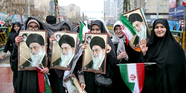 Iranian women hold up portraits of Iranian Supreme Leader Ayatollah Ali Khamenei, during a rally marking the 40th anniversary of the 1979 Islamic Revolution, in Tehran, Iran, Monday, Feb. 11, 2019.