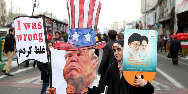 An Iranian woman holds an effigy of US president Donald Trump, during a rally marking the 40th anniversary of the 1979 Islamic Revolution, in Tehran, Iran, Monday, Feb. 11, 2019.