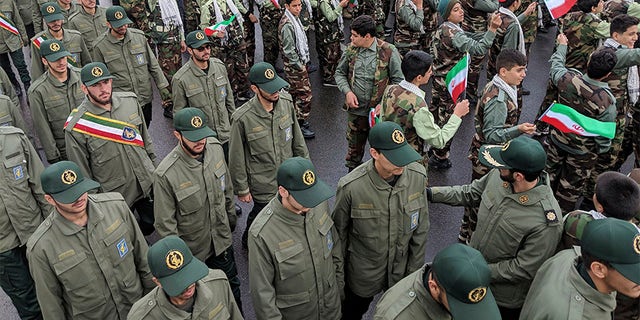School students wave their national flags as Revolutionary Guard members arrive in Azadi, freedom square, during a ceremony celebrating the 40th anniversary of Islamic Revolution, in Tehran, Iran, on Monday.
