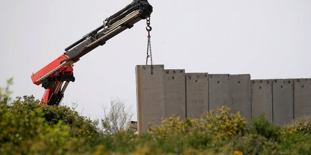An Israeli crane builds a wall near the border, seen from Lebanon, near the village of Naqoura, March 6, 2018.