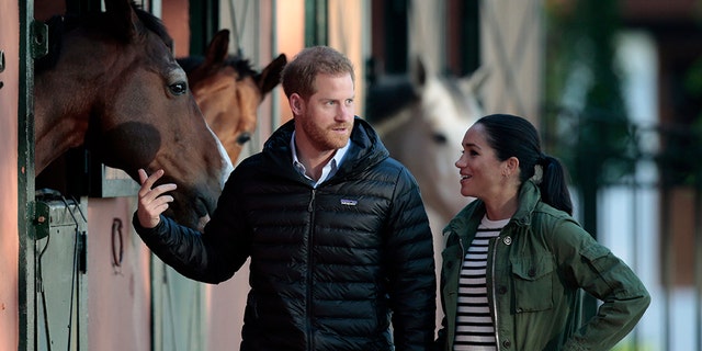 Britain's Prince Harry and Meghan, Duchess of Sussex, walk together during a visit to the Moroccan Royal Equestrian Sports Complex in Rabat, Morocco, Monday Feb. 25, 2019. The royal couple, who are expecting their first child in Spring 2019, are visiting the prestigious equestrian club to see the use of horses in therapy for children with disabilities. (AP Photo/Mosa'ab Elshamy)
