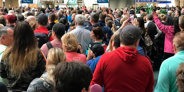   People are waiting to pass the security at Orlando International Airport following a security incident that occurred on Saturday after the flights were stuck as a result of. an alleged suicide. (Jonathan Hayward / Canadian Press via AP) 