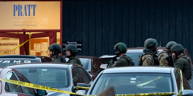 Police officers gather in front of Henry Pratt Co.'s manufacturing plant on Friday, February 15, 2019 in Aurora, Illinois. Police say that an armed man killed several people and injured police officers before being shot. (Associated Press)