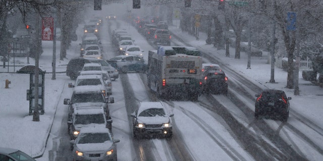 Cars and a bus make their way in the snow on Capitol Way, Friday, Feb. 8, 2019, in Olympia, Wash.
