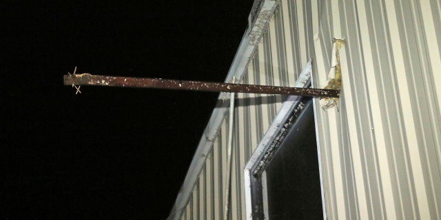 A metal pipe sticks through the outer wall of Fast Dog Printing Co., a tornado hit in the area Saturday, February 23, 2019.