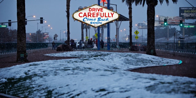 Snow accumulates on a median along the Las Vegas Strip at the "Welcome to Fabulous Las Vegas" sign, Thursday, Feb. 21, 2019, in Las Vegas.