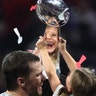 Tom Brady of the New England Patriots celebrates with daughter Vivian Lake Brady while they hold the Vince Lombardi trophy after the Patriots won Super Bowl LIII in Atlanta, Feb. 3, 2019.