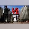 Newlyweds Jennifer and Paul Raffa pose for a photograph with the Robert Indiana sculpture "LOVE" at John F. Kennedy Plaza on Valentine's Day in Philadelphia, Feb. 14, 2019.