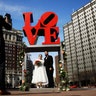 Newlyweds Jennifer and Paul Raffa pose for a photograph with the Robert Indiana sculpture "LOVE" at John F. Kennedy Plaza on Valentine's Day in Philadelphia, Feb. 14, 2019.