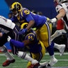 New England Patriots Tom Brady fumbles the ball under pressure from Los Angeles Rams' John Franklin-Myers and Ethan Westbrooks in the Super Bowl in Atlanta, February 3. 2019.