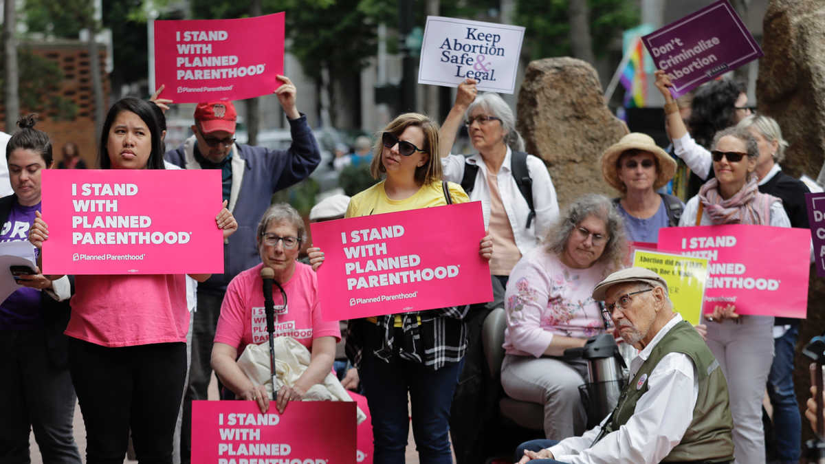 In this July 10, 2018, photo, protesters hold signs supporting Planned Parenthood in Seattle. (AP Photo/Ted S. Warren, File)