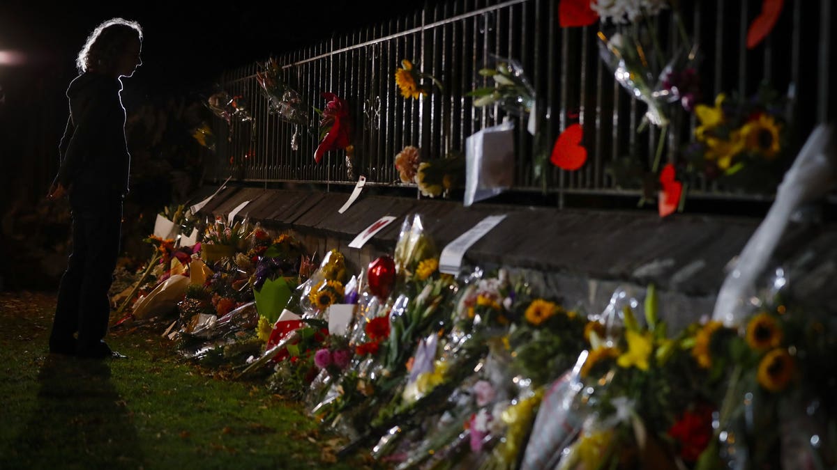 Mourners pay their respects at a makeshift memorial near the Masjid Al Noor mosque in Christchurch, New Zealand, Saturday, March 16, 2019. New Zealand's stricken residents reached out to Muslims in their neighborhoods and around the country on Saturday, in a fierce determination to show kindness to a community in pain as a 28-year-old white supremacist stood silently before a judge, accused in mass shootings at two mosques that left dozens of people dead.