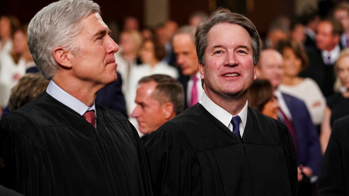 Justice Gorsuch and Justice Kavanaugh stand next to each other