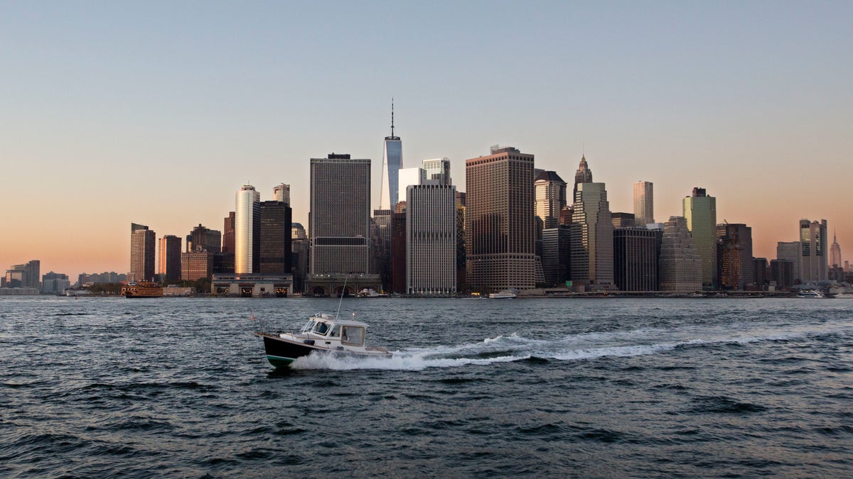 FILE - In this Oct. 19, 2017 file photo, a boat crosses New York Harbor in front of the Manhattan skyline. Mayor Bill de Blasio is announcing a plan to protect lower Manhattan from rising sea levels by surrounding it with earthen berms and extending its shoreline by as much as 500 feet. (AP Photo/Mark Lennihan, File)