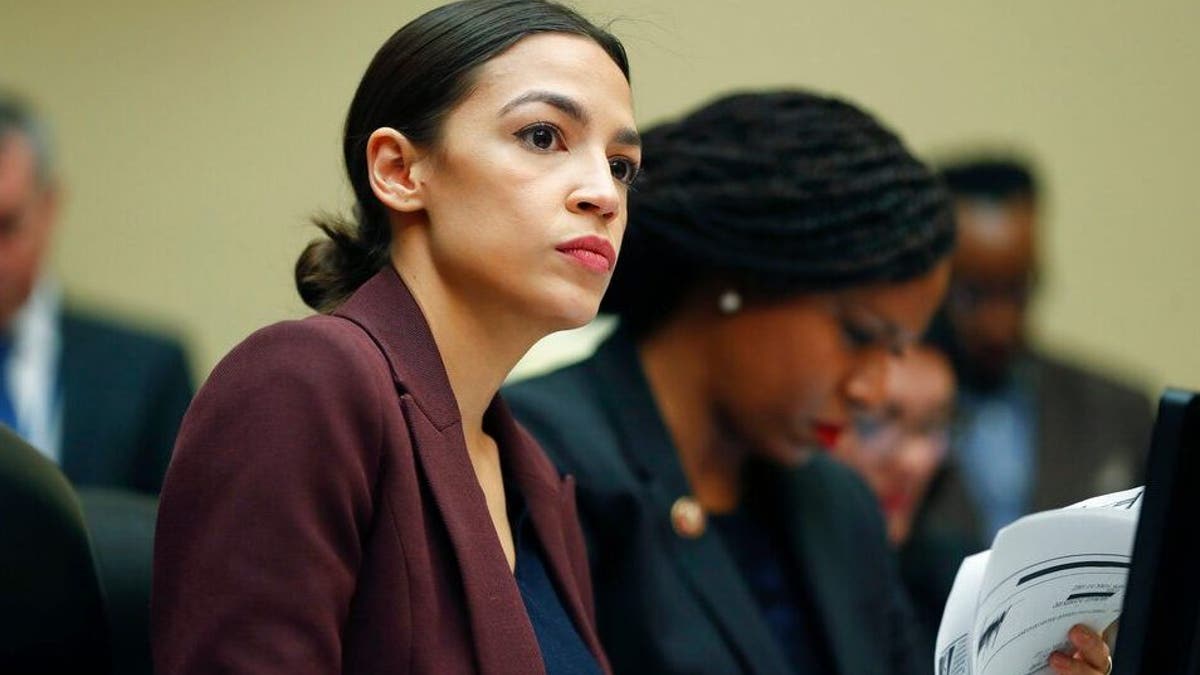 Rep. Alexandria Ocasio-Cortez, D-N.Y., left, looks over her notes during testimony by Michael Cohen, President Donald Trump's former lawyer, before the House Oversight and Reform Committee on Capitol Hill in Washington, Wednesday, Feb. 27, 2019. Sitting next to Ocasio-Cortez is Rep. Ayanna Pressley, D-Mass., right. (AP Photo/Pablo Martinez Monsivais)