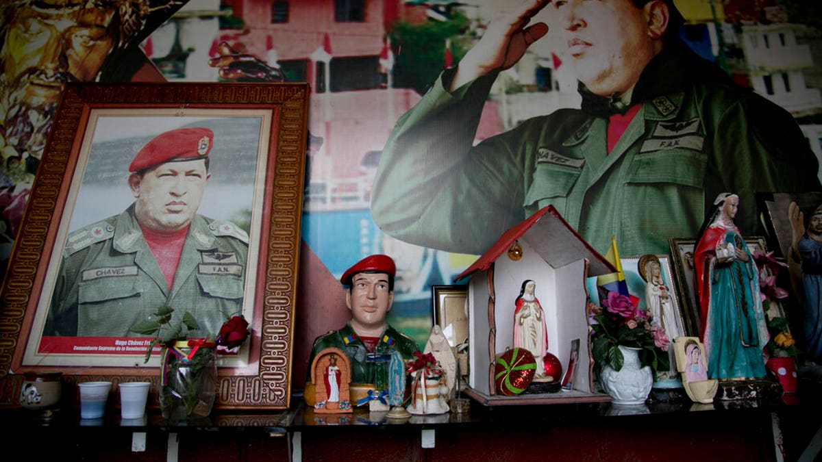 Images of Venezuela's late President Hugo Chavez are surrounded by religious iconography inside a small chapel in the 23 de Enero neighborhood of Caracas, Venezuela, Saturday, March 2, 2019. (AP Photo/Eduardo Verdugo)