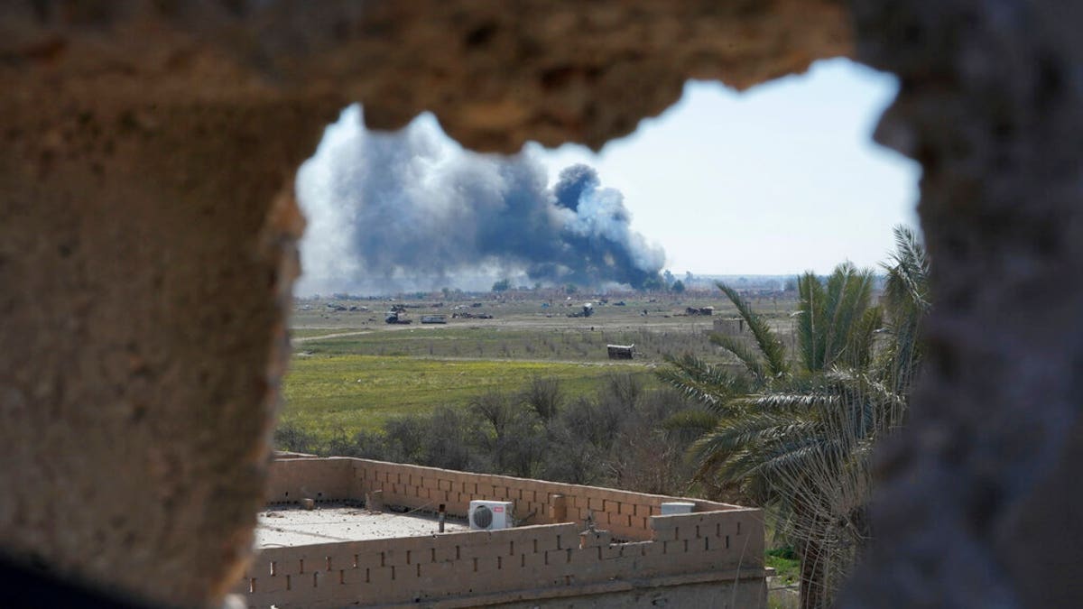 Columns of black smoke billow from the last small piece of territory held by Islamic State militants as U.S. backed fighters pounded the area with artillery fire and occasional airstrikes in Baghouz, Syria, Sunday, March 3, 2019. (AP Photo/Andrea Rosa)