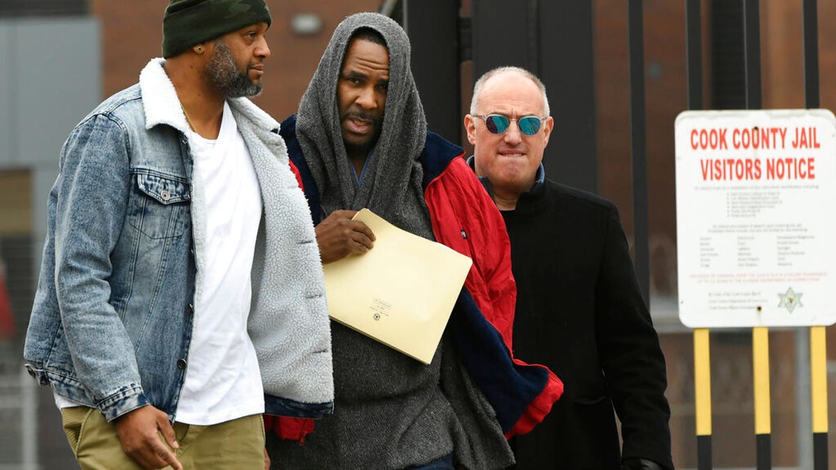 Singer R. Kelly, center, walks with his attorney Steve Greenberg, right, and an unidentified man who gave him a ride after being released from Cook County Jail, March 9, 2019, in Chicago. Kelly walked out of jail after a $161,000 child support payment was made on his behalf.