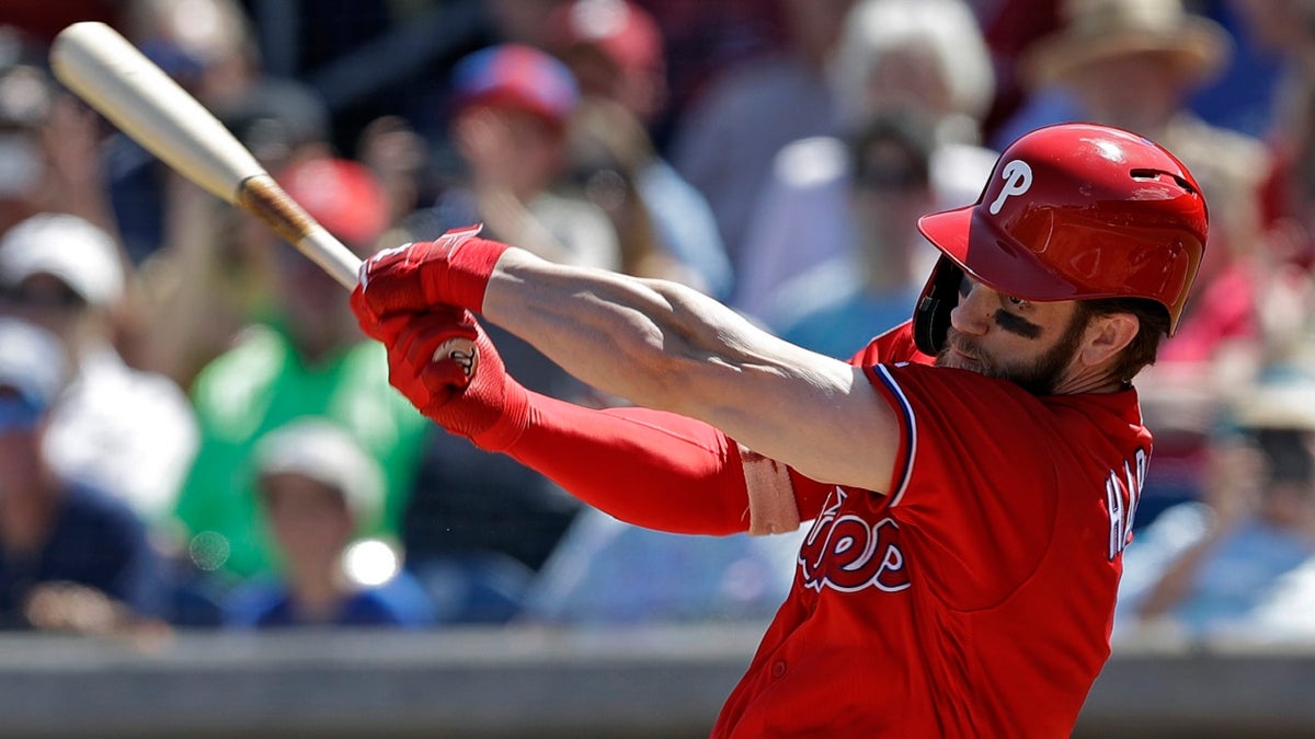 Philadelphia Phillies' Bryce Harper swings at a pitch from Toronto Blue Jays' Matt Shoemaker during the first inning of a spring training baseball game Saturday, March 9, 2019, in Clearwater, Fla. (Associated Press)