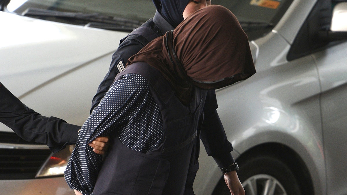 Vietnamese Doan Thi Huong, foreground, is escorted by police as she arrives at Shah Alam High Court in Shah Alam, Malaysia, Monday, March 11, 2019. The trial of two Southeast Asian women charged with murdering Kim Jong Nam, North Korean leader's half brother, resumed Monday after months of delay, with the Vietnamese suspect taking the stand to begin her defense. (AP Photo/Yam G-Jun)