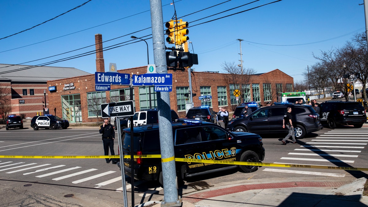 Swarms of police respond to Grifols Biomat USA Plasma Center on reports of shots fired in downtown Kalamazoo, Michigan on Tuesday, March 12, 2019. Authorities say a police officer has been shot while responding to the shooting. (Joel Bissell/Kalamazoo Gazette via AP)