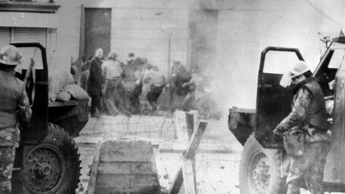 In this Jan. 30, 1972 file photo, soldiers take cover behind their sandbagged armored cars in Londonderry, Northern Ireland.