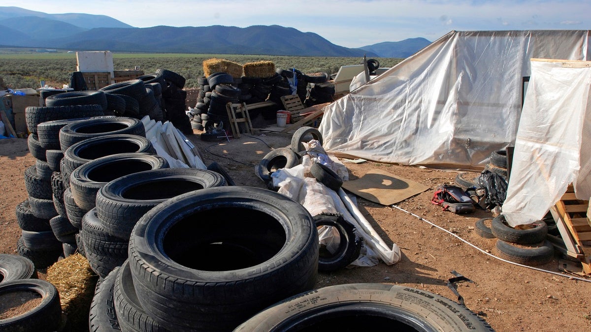 FILE: A makeshift living compound in Amalia, N.M., Aug. 10, 2018. Five former residents of a New Mexico compound where authorities found 11 hungry children and a dead 3-year-old boy are due in federal court on terrorism-related charges.