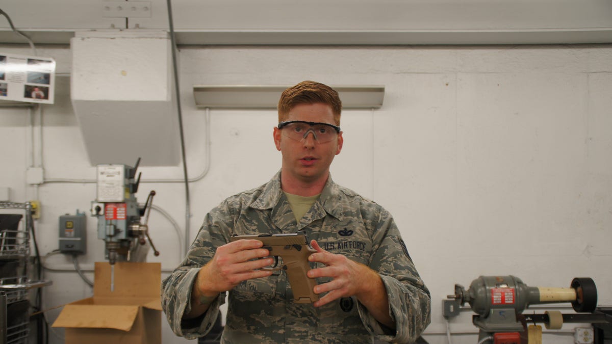Tech. Sgt. Brady Craddock, non-commissioned officer in charge of the Air Force Gunsmith Shop, explains the benefits of the M18 modular handgun system. (U.S. Air Force photo by Vicki Stein/Released)