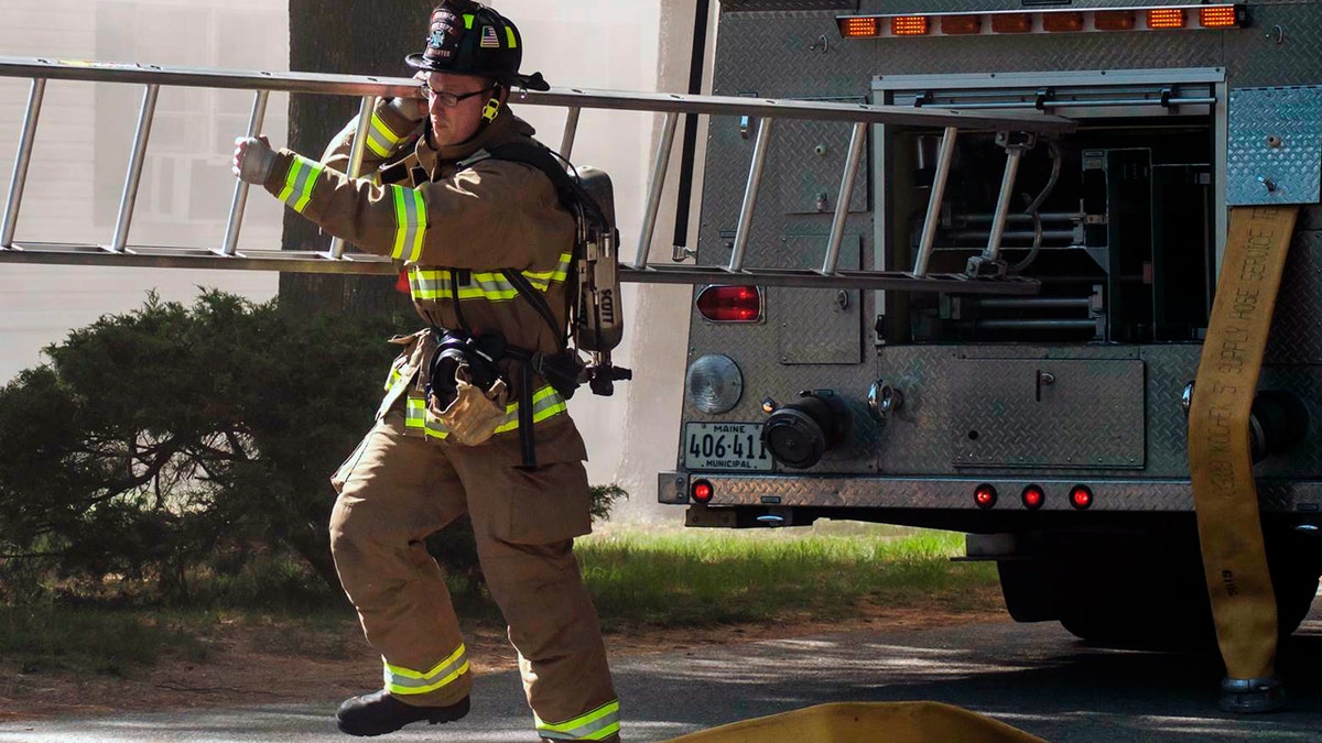 Berwick Fire Capt. Joel Barnes pulling a ladder on the scene of a June 2017 structure fire in Somersworth N.H. (Erin Thomas via AP, File)