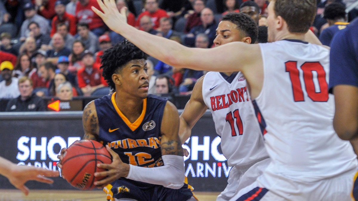 Murray State's Ja Morant (12) looks for an opening as Belmont's Kevin McClain (11) and Caleb Hollander (10) defend during the second half of an NCAA college basketball game for the championship of the Ohio Valley Conference men's tournament Saturday, March 9, 2019, in Evansville, Ind.