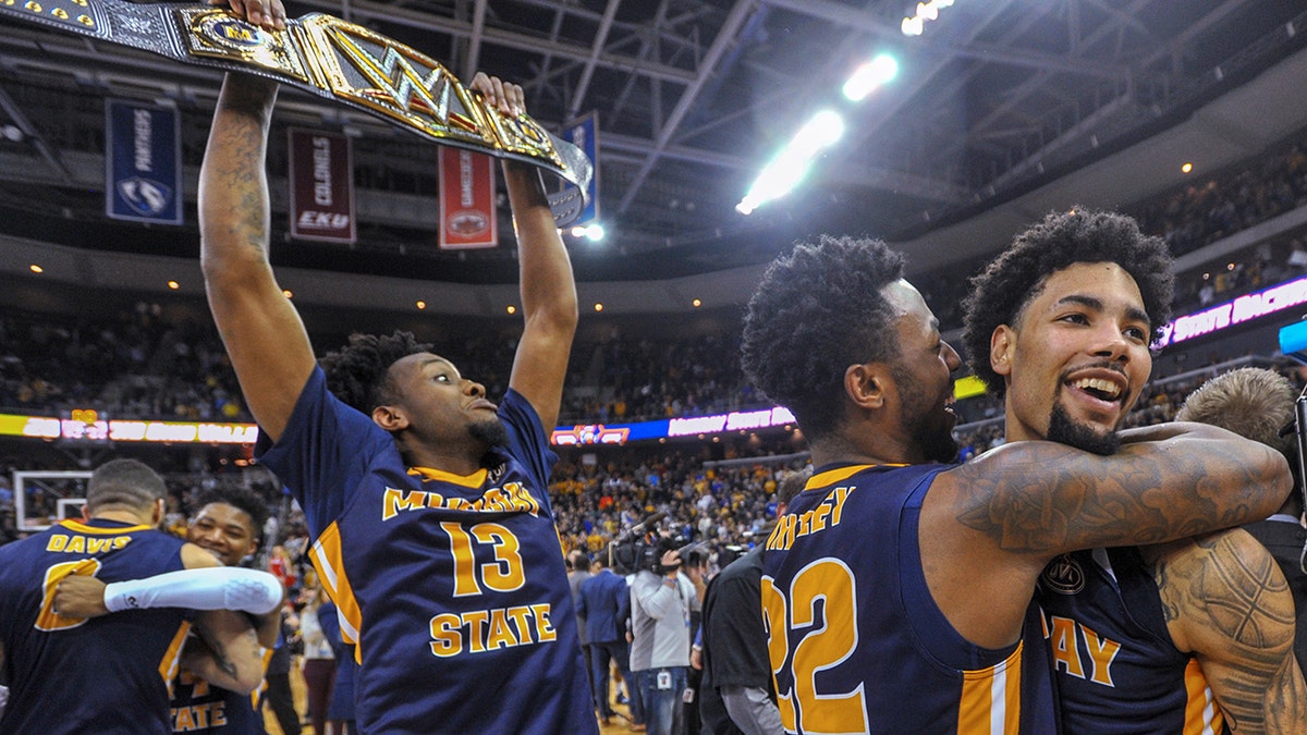 Murray State's Brion Whitley (22) hugs Tevin Brown (10) as Devin Gilmore (13) celebrates behind them the team's win over Belmont in an NCAA college basketball game for the championship of the Ohio Valley Conference men's tournament Saturday, March 9, 2019, in Evansville, Ind. (AP Photo/Daniel R. Patmore)
