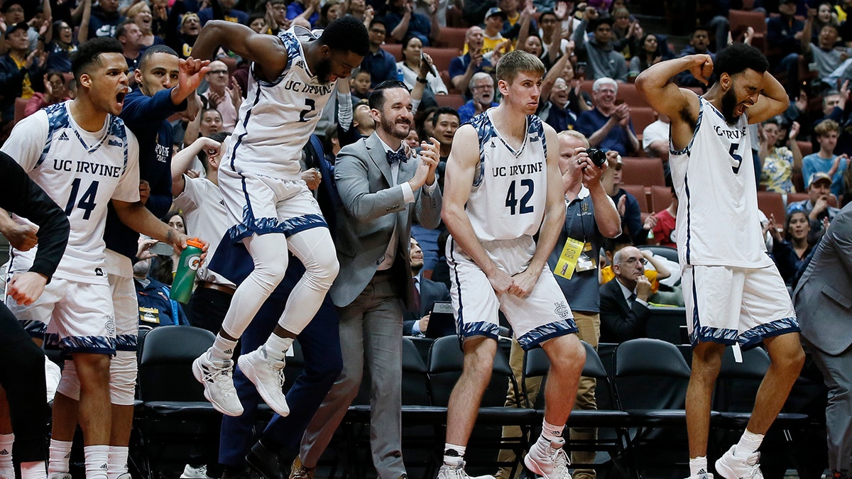 UC Irvine starters guard Evan Leonard (14), guard Max Hazzard (2), forward Tommy Rutherford (42) and forward Jonathan Galloway (5) celebrate in the last seconds of the second half of an NCAA college basketball game against Cal State Fullerton for the Big West men's tournament championship in Anaheim, Calif., Saturday, March 16, 2019. (AP Photo/Alex Gallardo)