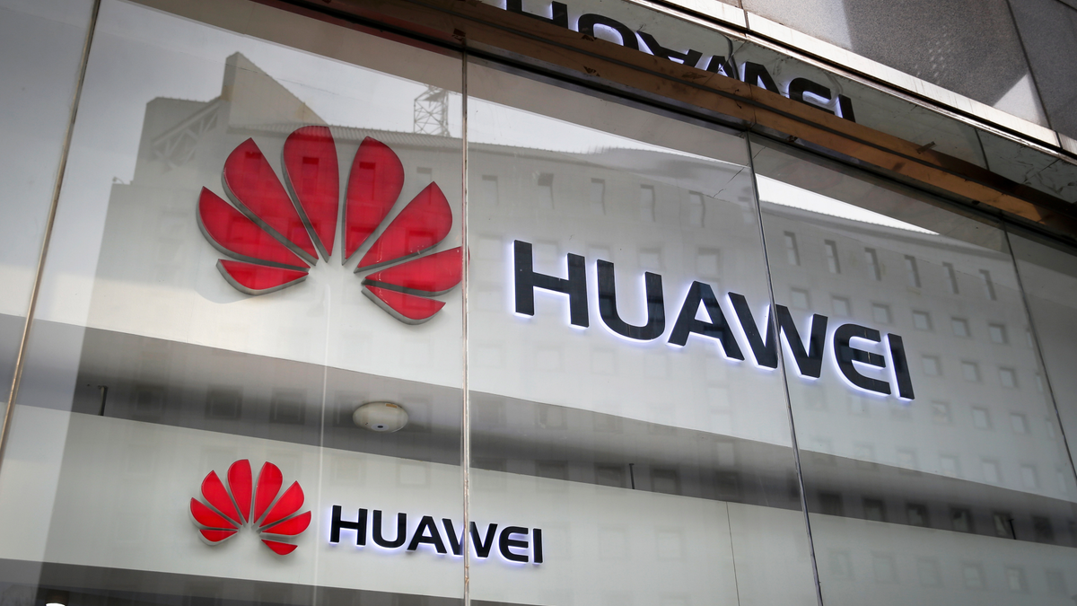FILE - In this Jan. 29, 2019, file photo, the logos of Huawei are displayed at its retail shop window reflecting the Ministry of Foreign Affairs office in Beijing. (AP Photo/Andy Wong, File)